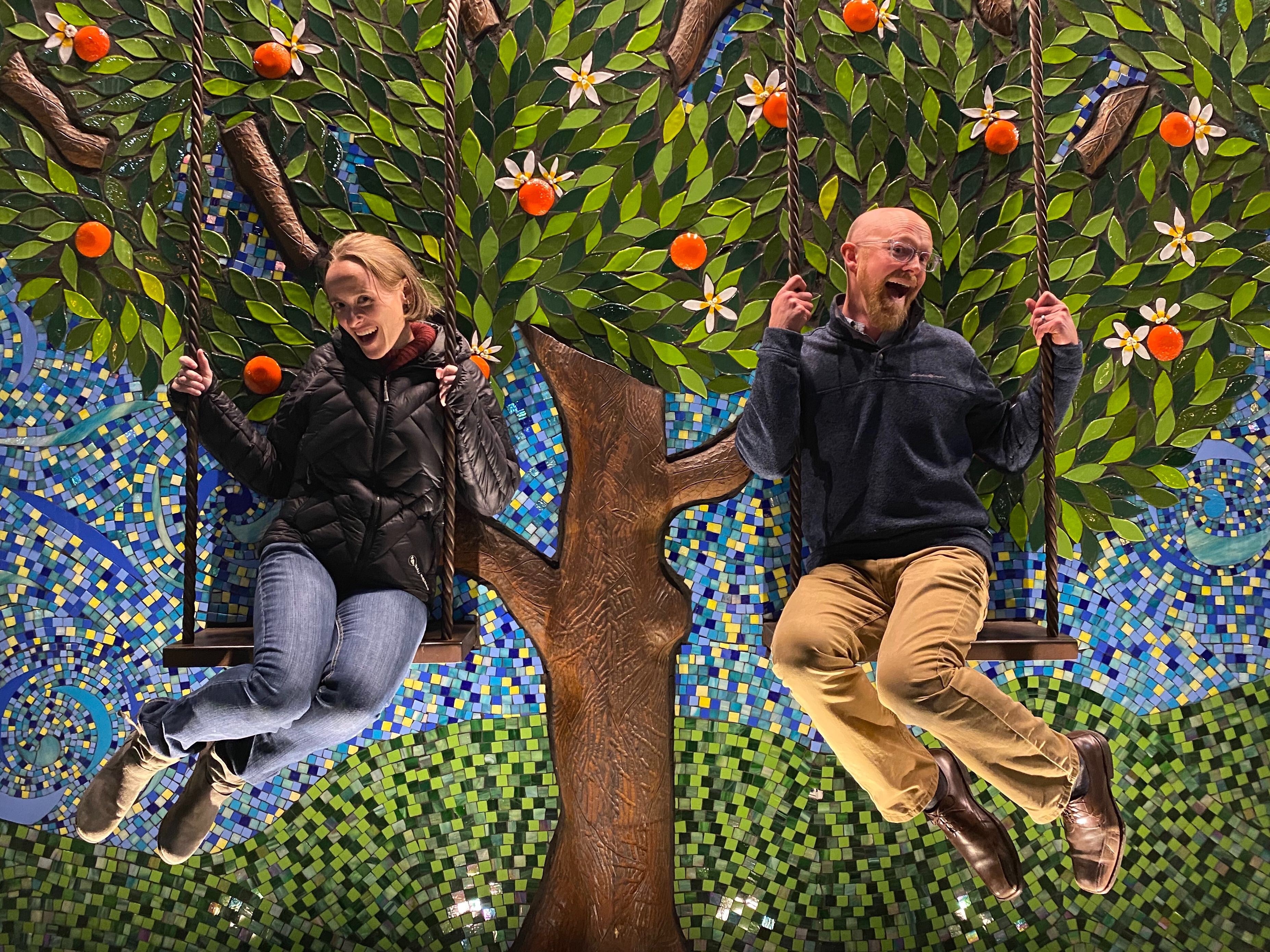 A photo of Chris and Amanda joyfully frolicking on the swings at the Lab-Aids team meeting